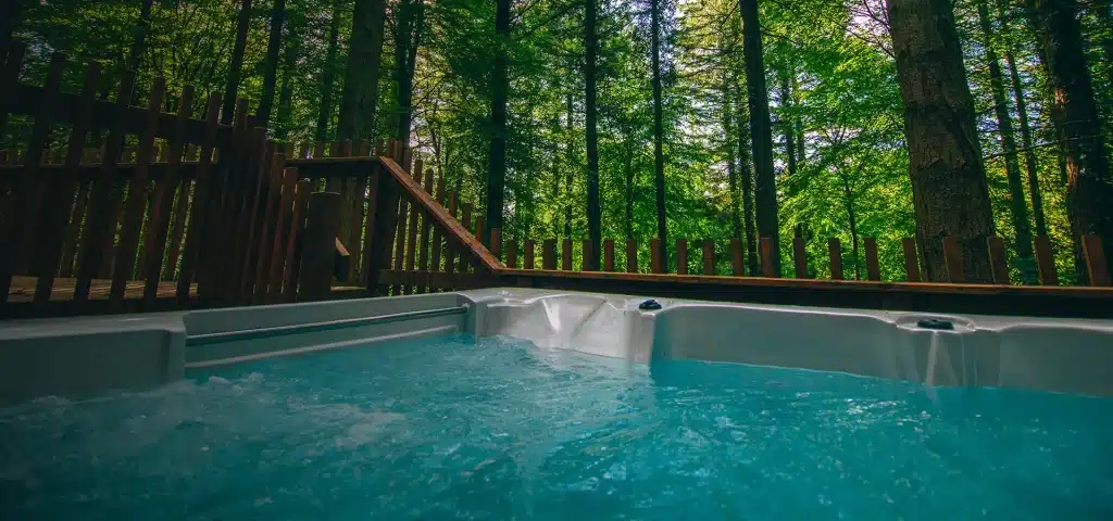 Photo of a Spa in a forest. An ICO Spa probe is immersed in the water to analyze and advise on spa maintenance. 