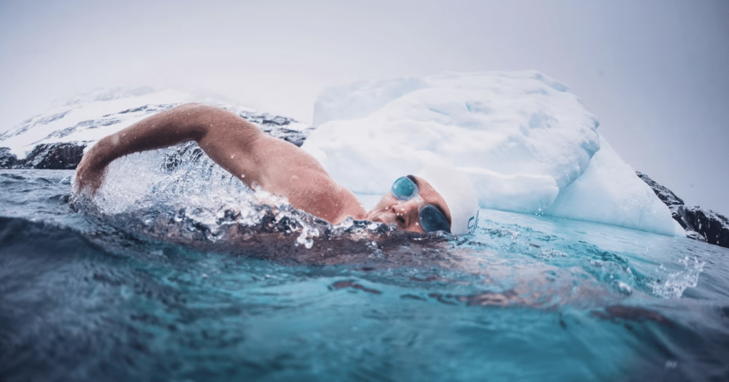 Le nageur Lewis Pugh nage en eau froide à côté d'un iceberg