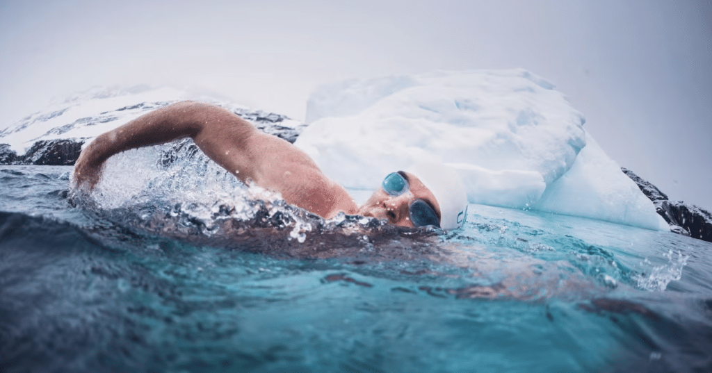 Schwimmer Lewis Pugh schwimmt in kaltem Wasser neben einem Eisberg